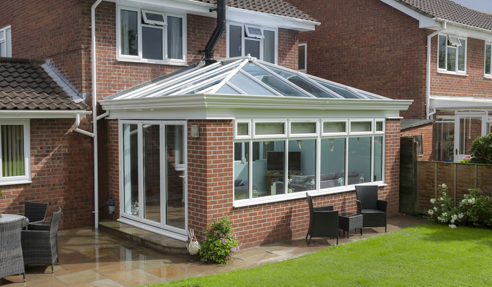 Modern orangery extension opening onto a garden patio